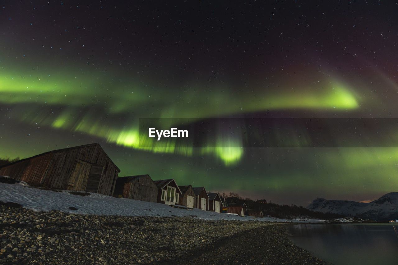 aurora, night, star, sky, astronomy, space, beauty in nature, scenics - nature, environment, aurora polaris, landscape, nature, dramatic sky, natural phenomenon, cold temperature, green, snow, illuminated, winter, mountain, light - natural phenomenon, tranquility, mystery, space and astronomy, science, polar climate, land, travel destinations, no people, architecture, awe, tranquil scene, atmospheric mood, idyllic, water, dramatic landscape, outdoors, cloud, long exposure, non-urban scene, glowing, travel