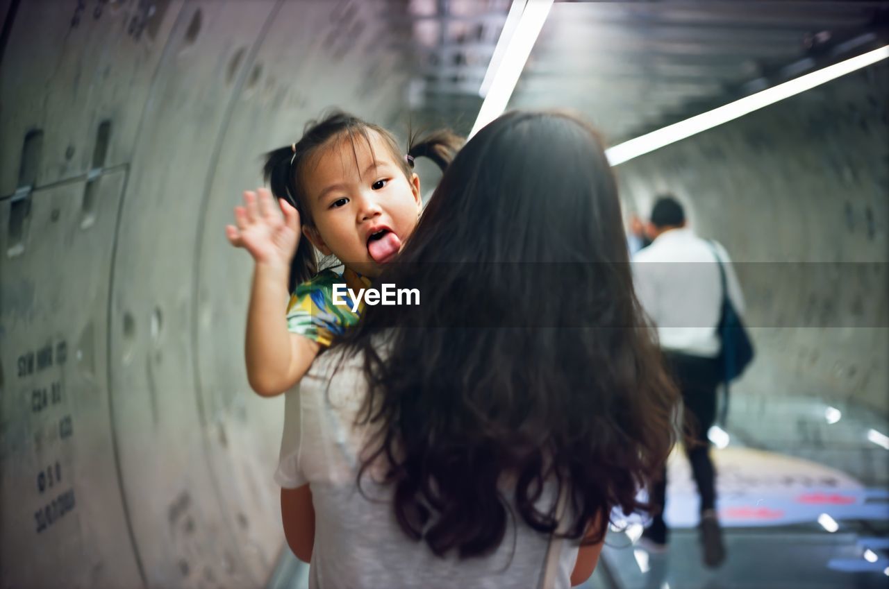 Portrait of cute girl with mother in tunnel