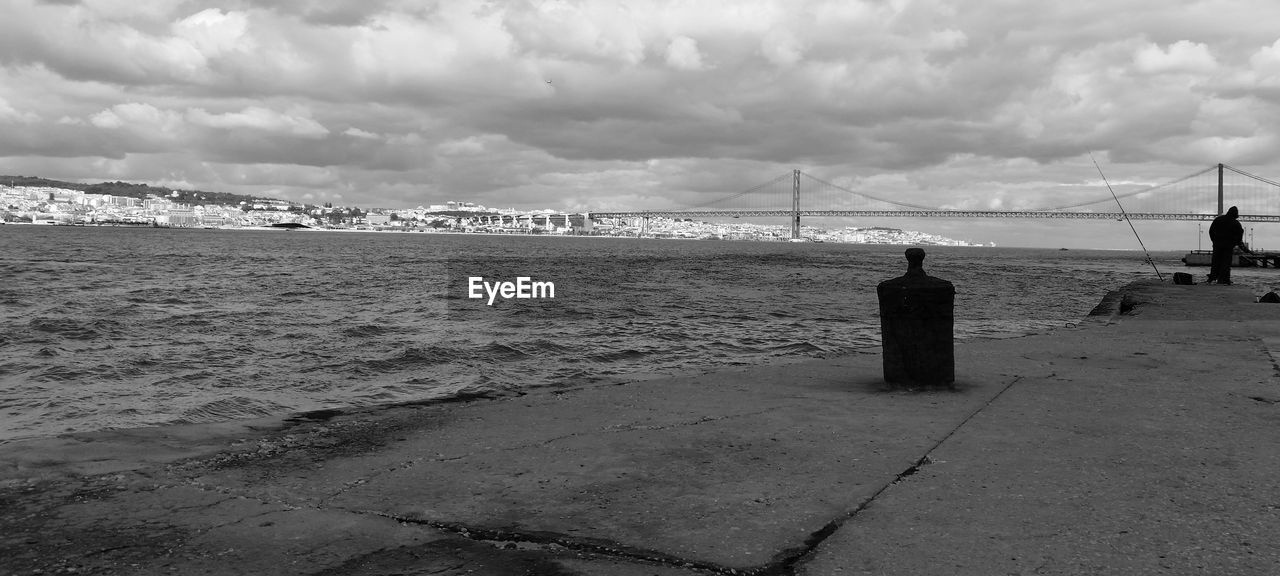 April 25th bridge over tagus river against cloudy sky