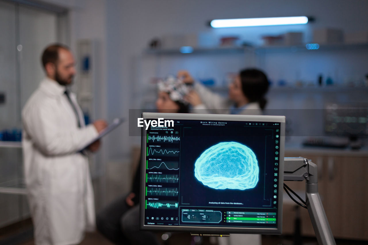 Side view of man using laptop at clinic