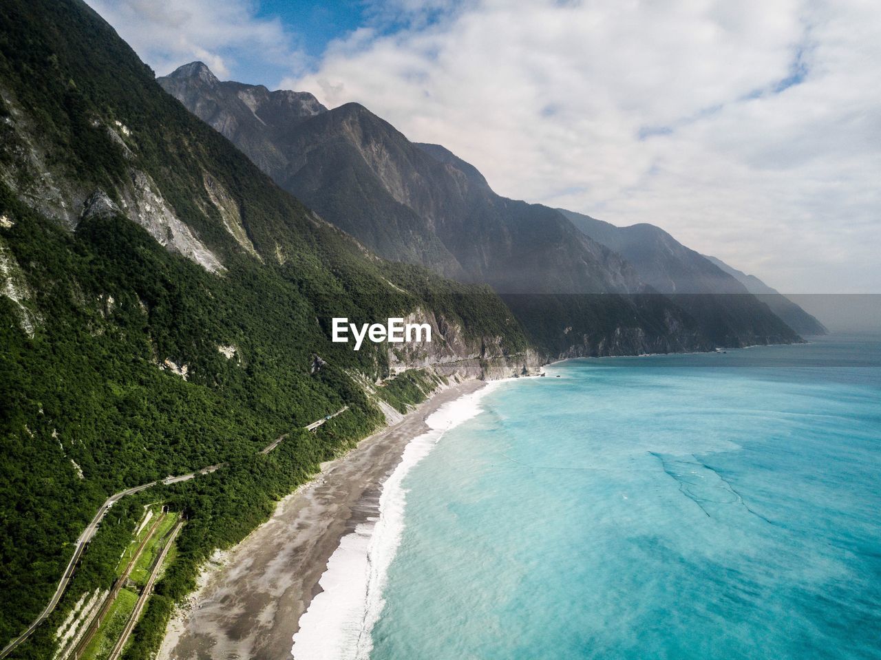 Scenic view of sea and mountains against sky