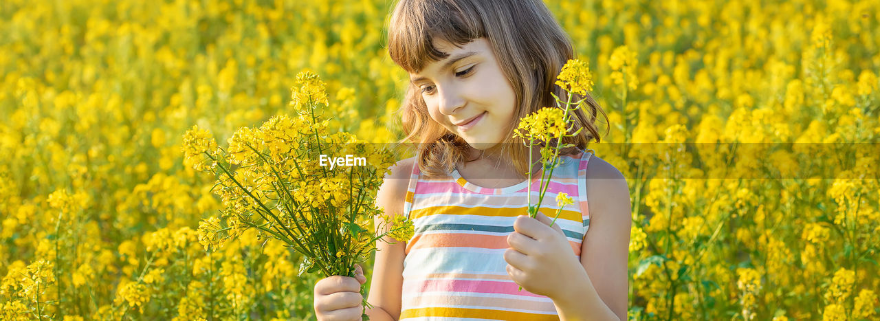 yellow, rapeseed, childhood, food, canola, flower, child, plant, vegetable, flowering plant, one person, women, field, produce, smiling, mustard, happiness, nature, rural scene, growth, female, meadow, oilseed rape, beauty in nature, landscape, summer, agriculture, freshness, emotion, land, crop, springtime, hairstyle, casual clothing, cute, outdoors, portrait, sunlight, farm, lifestyles, enjoyment, day, leisure activity, cheerful, positive emotion, standing, joy, looking, brassica rapa, innocence, long hair, food and drink, environment, plain, waist up, carefree, front view, blossom, adult