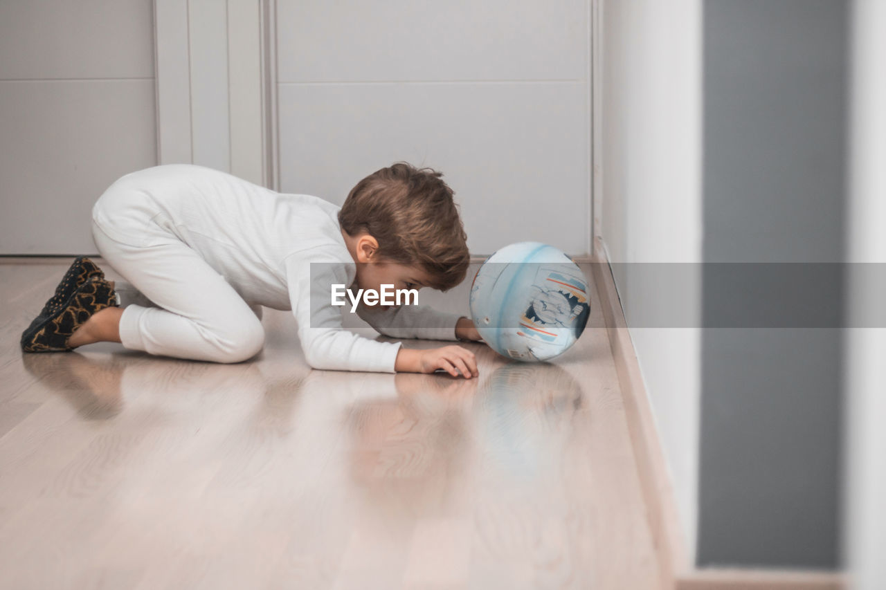 PORTRAIT OF BOY LYING DOWN ON FLOOR