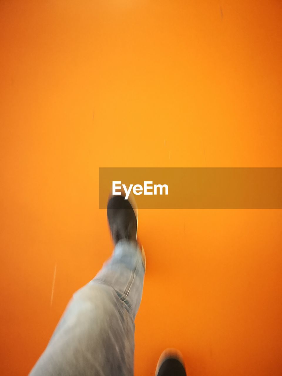 LOW SECTION OF MAN STANDING ON ORANGE