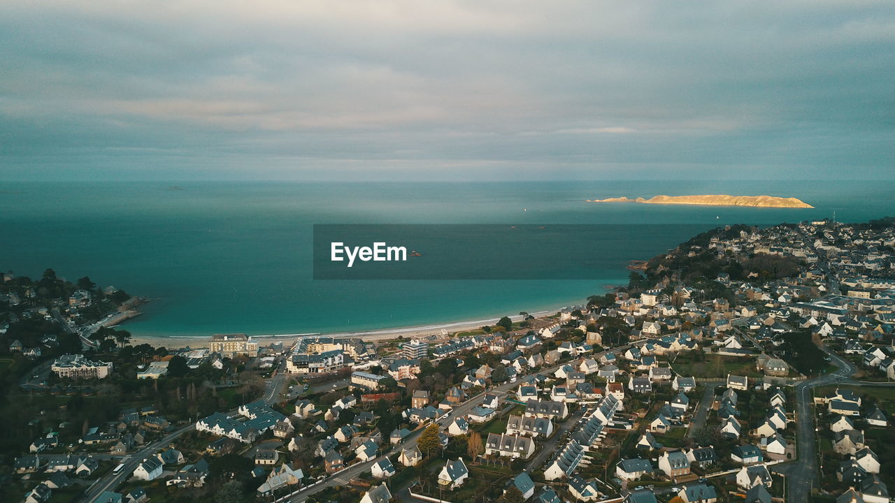 High angle view of townscape by sea against sky