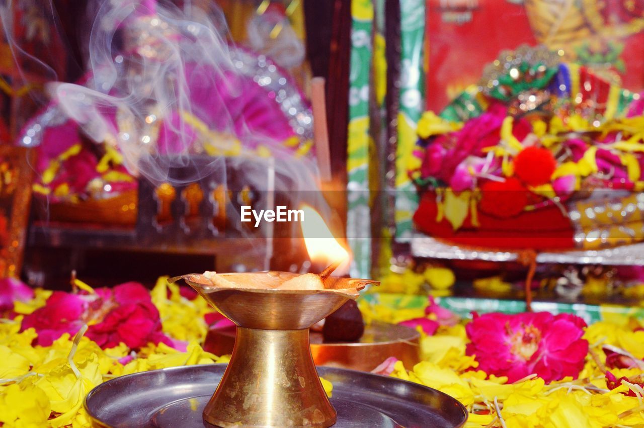 Close-up of illuminated diya during traditional ceremony