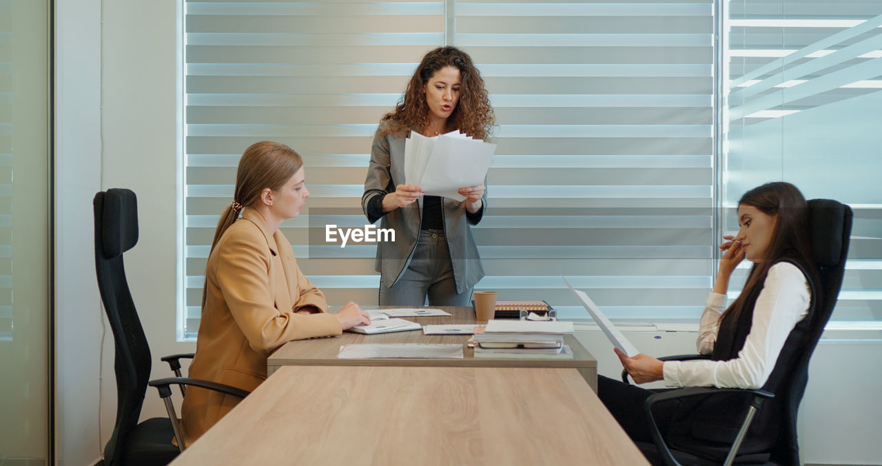 Angry buisness woman boss shouting at her employees during meeting conference leaving the room. 