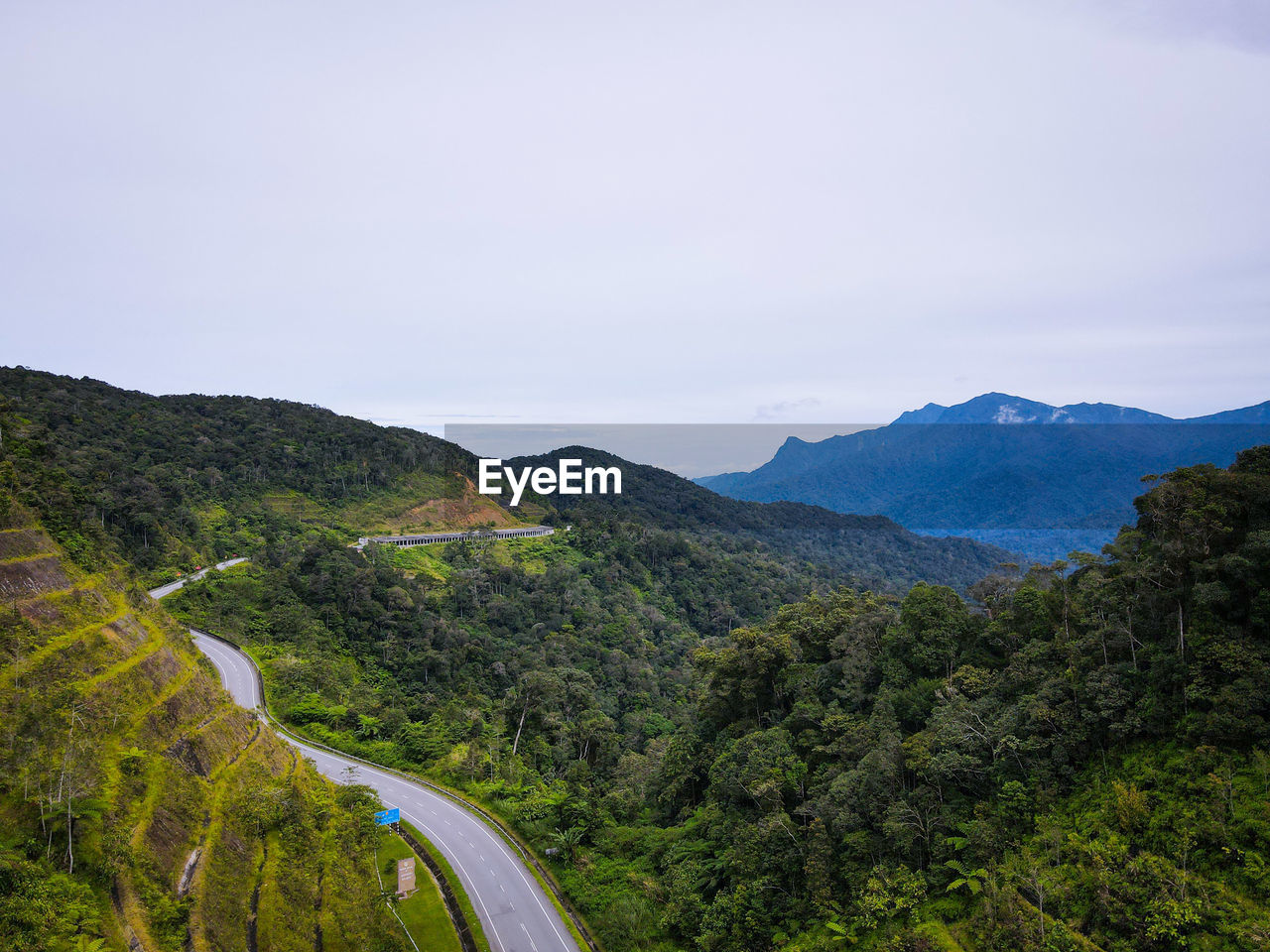 HIGH ANGLE VIEW OF ROAD AMIDST MOUNTAINS AGAINST SKY