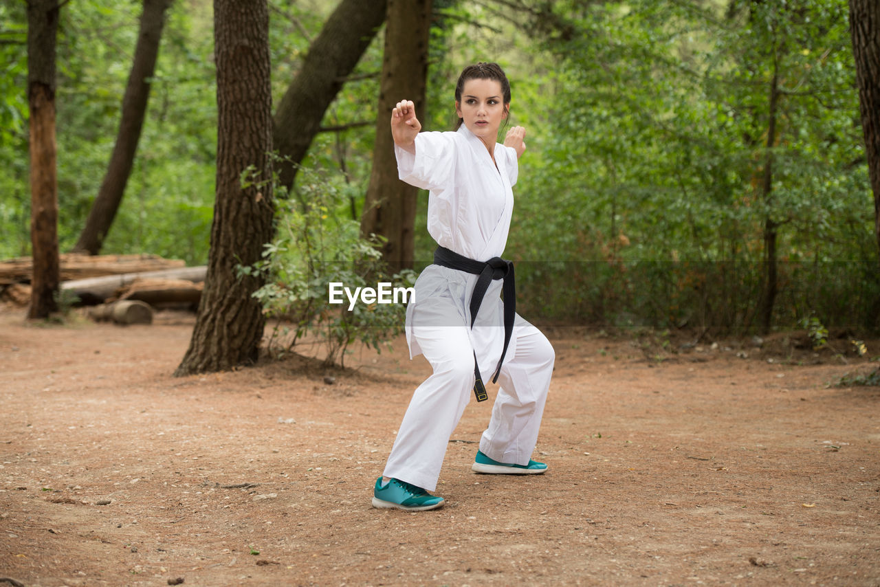 full length of young woman exercising on field