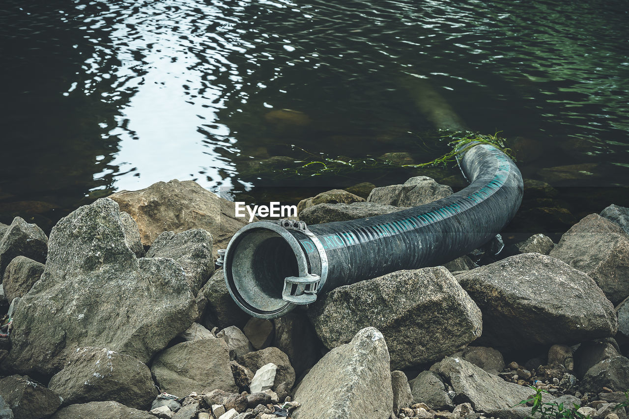 A pipeline protrudes from the river danube in regensburg to the shore