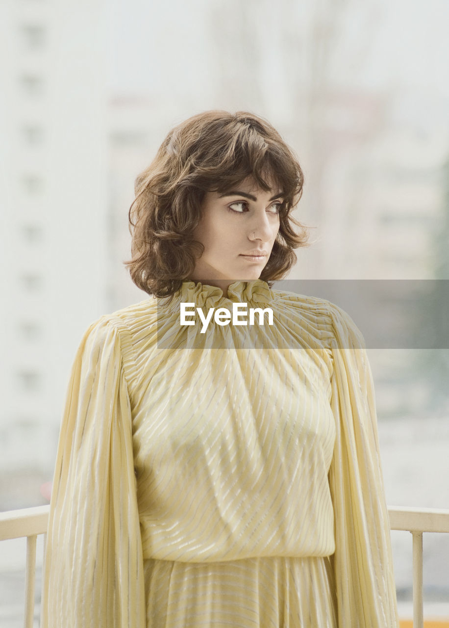 Woman looking away while standing at balcony