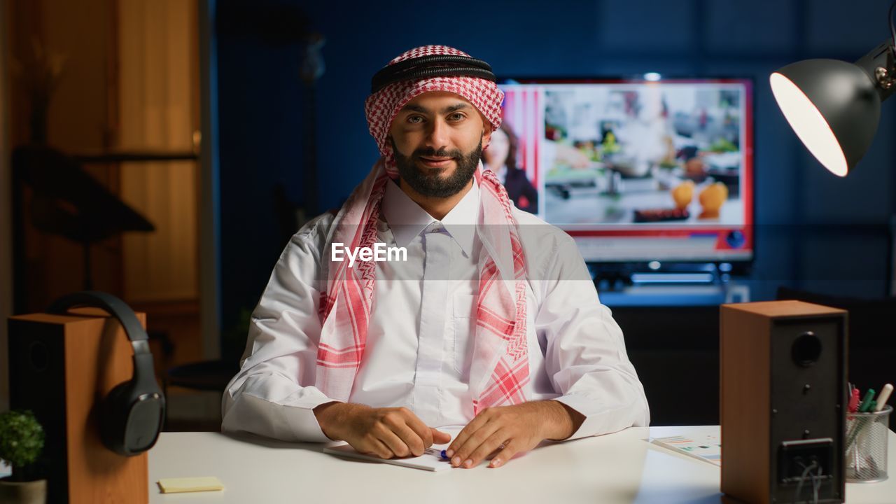 portrait of young man using mobile phone in office