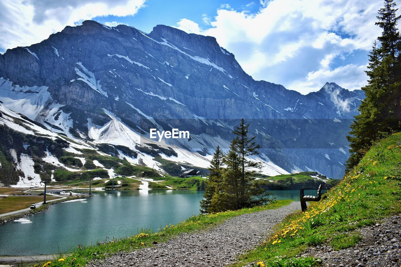 Scenic view of lake by snowcapped mountains against sky