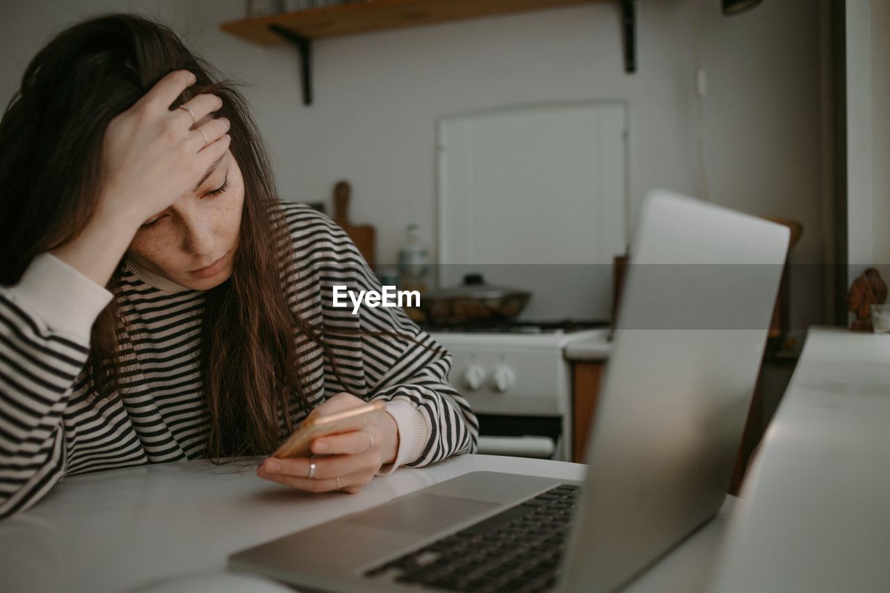 Woman watching on mobile screen with unhappy face reading news 