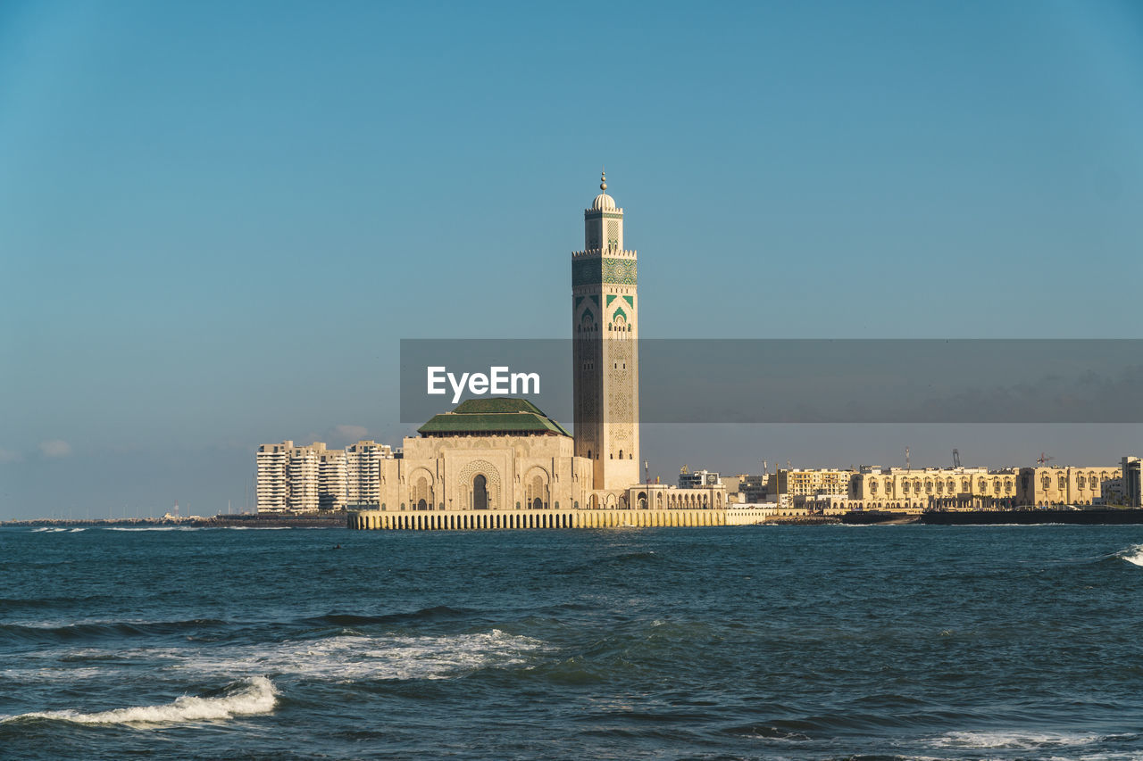 View of building by sea against clear sky