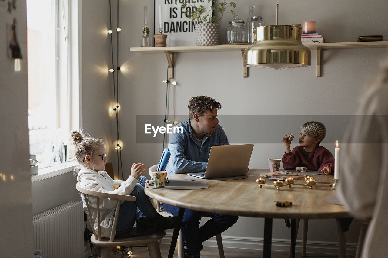 Father sitting with children at table