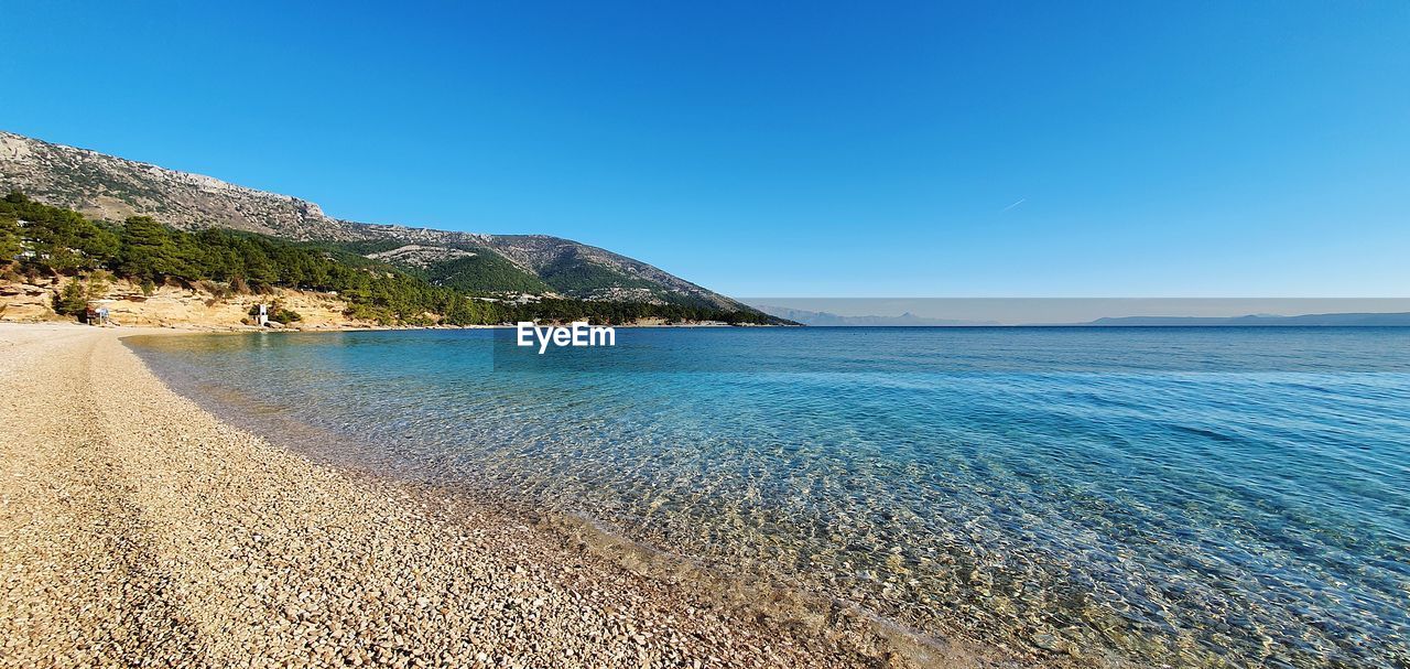 Scenic view of sea against clear blue sky