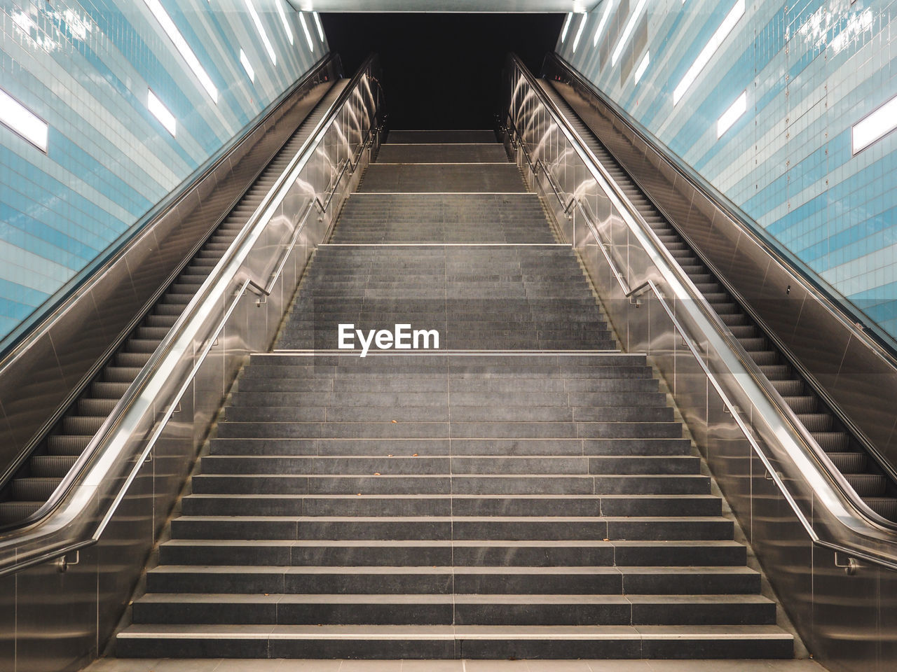 Low angle view of staircase amidst escalators at subway station