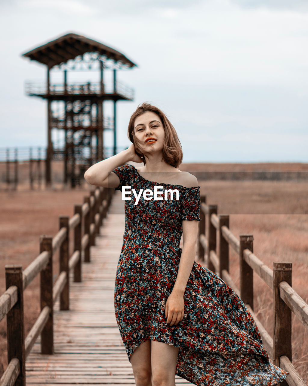 PORTRAIT OF WOMAN STANDING AGAINST SKY