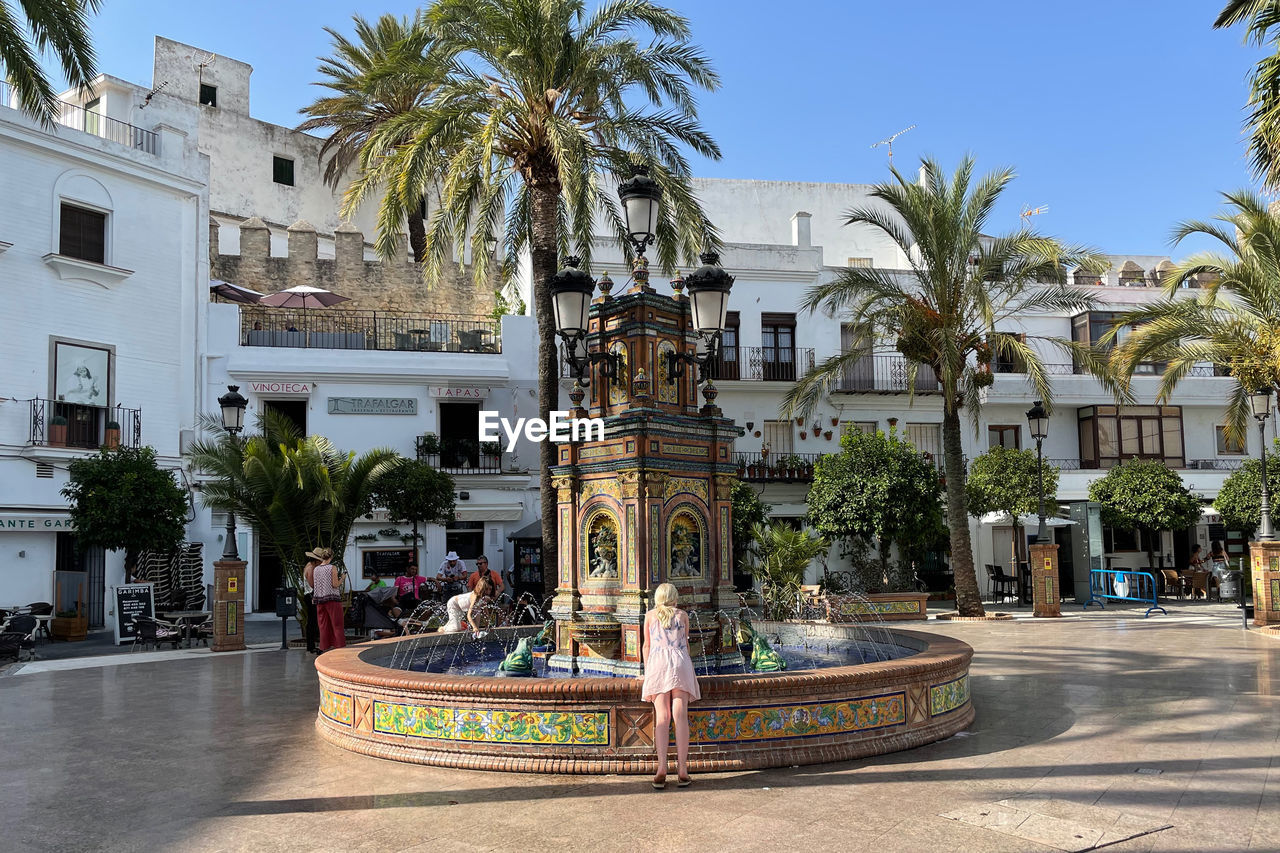 Little girl at the spanish village plaza fountain 