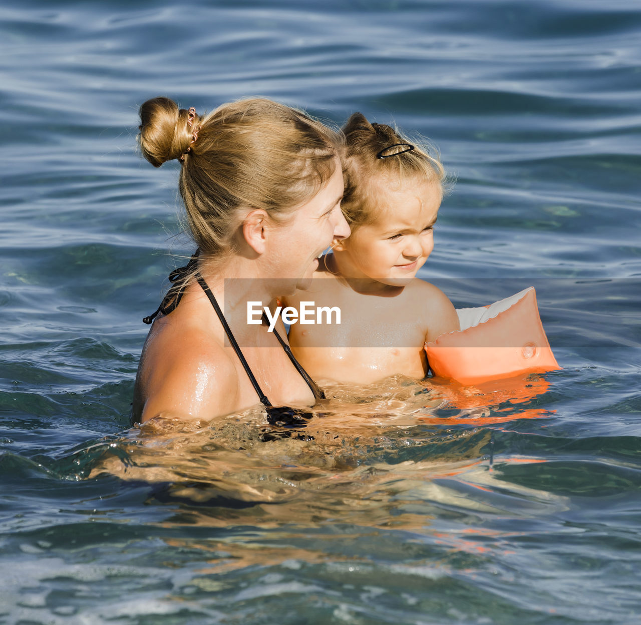 Mother and daughter swimming in sea