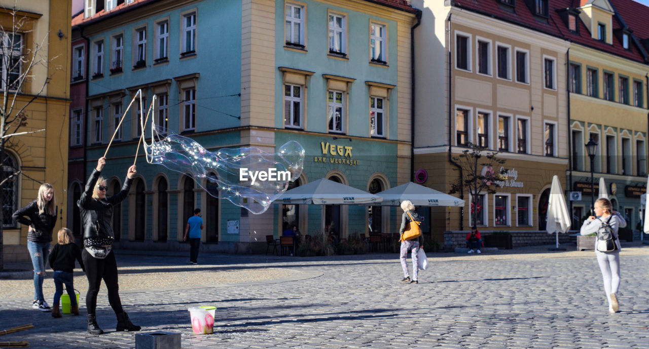 PEOPLE IN FRONT OF BUILDING AT STREET