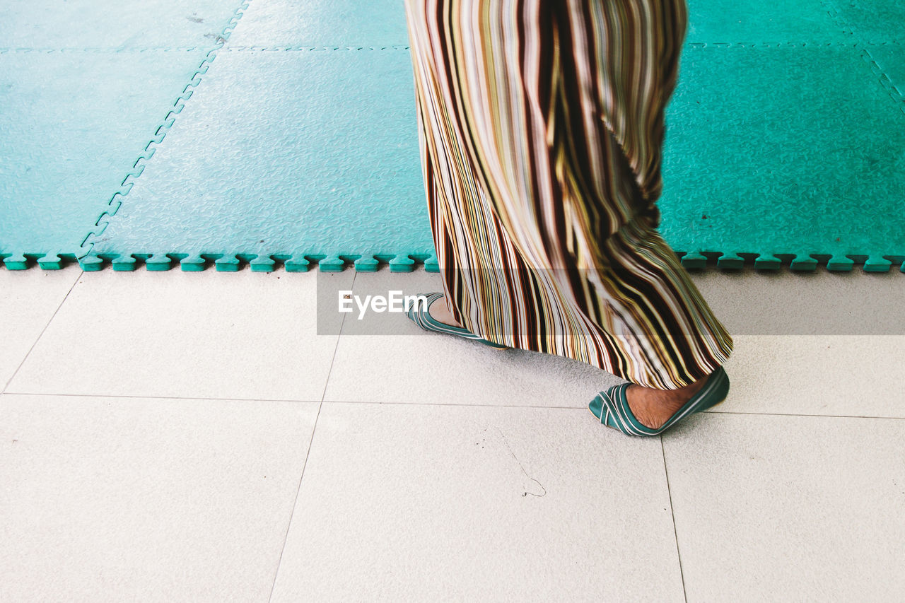 Low section of woman walking on floor