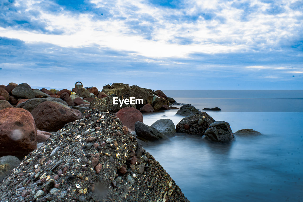 Rocks in sea against sky