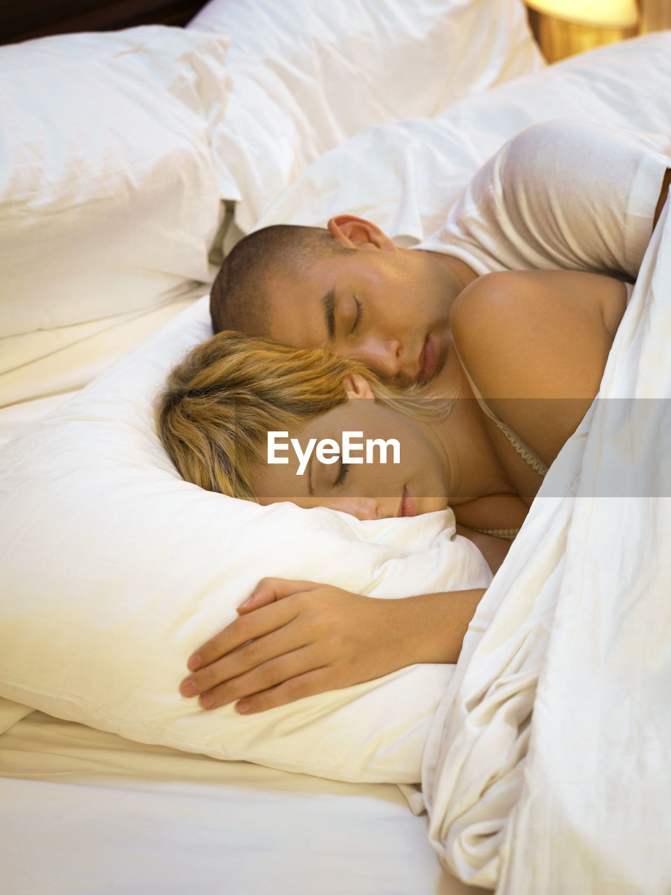 High angle view of couple sleeping on bed at home