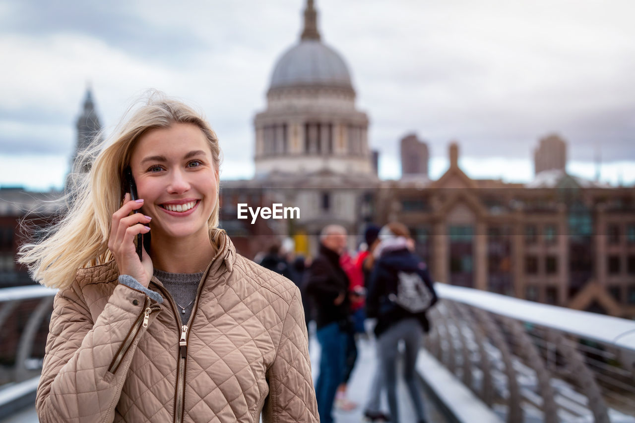 Portrait of smiling young woman on bridge