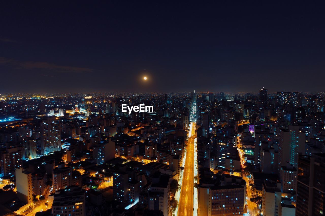 Illuminated cityscape against sky at night