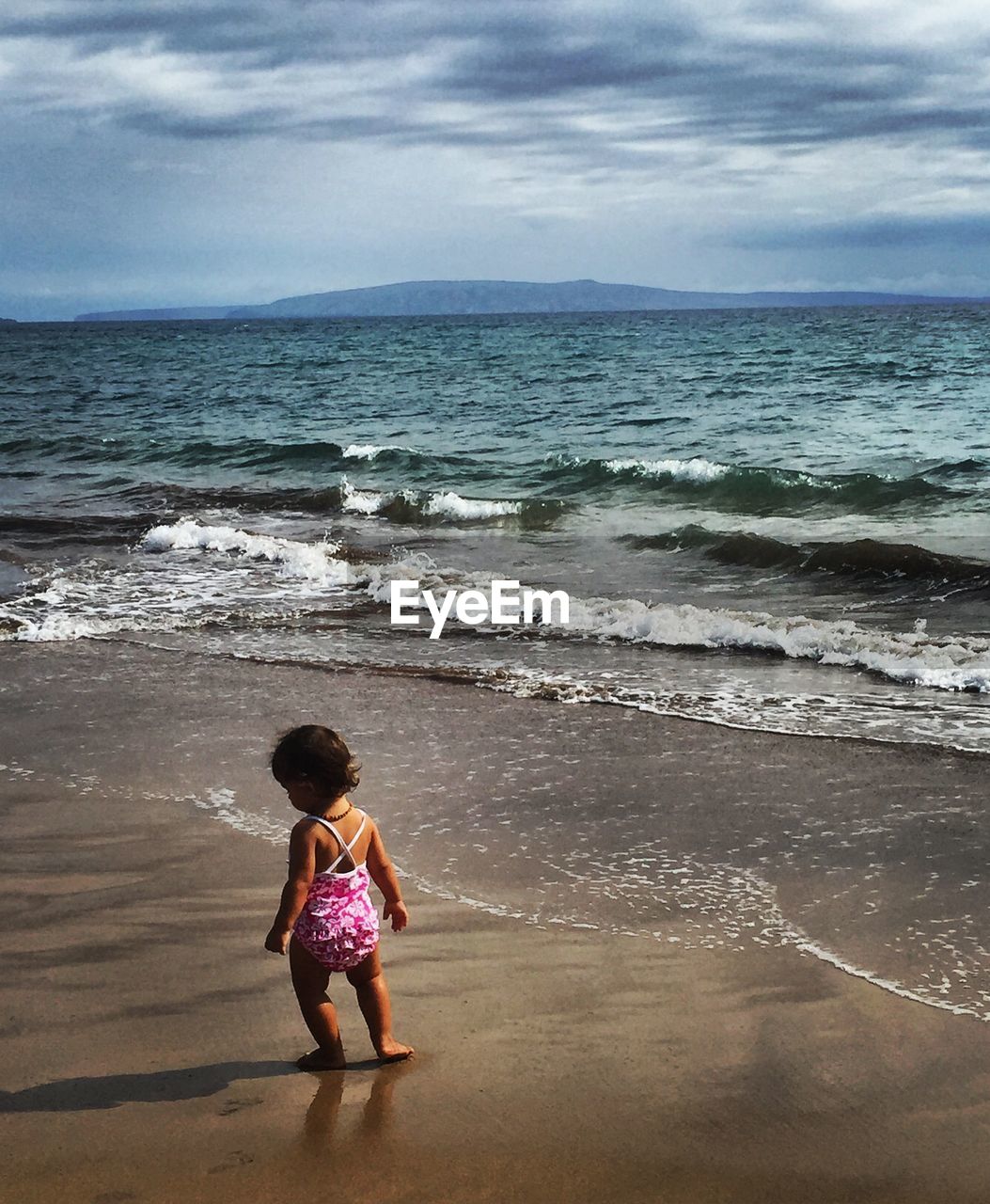 Full length of girl on beach against sky
