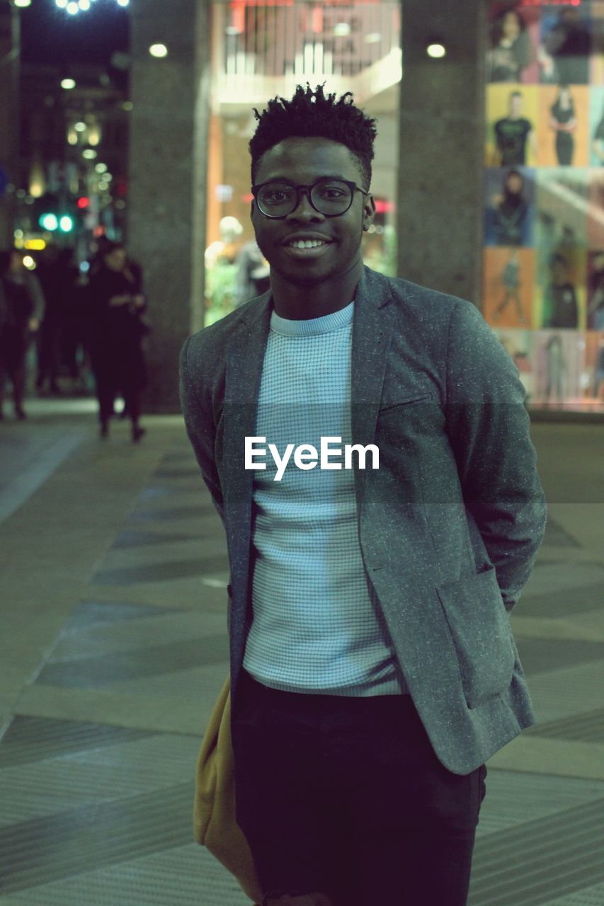 Portrait of young man standing in city