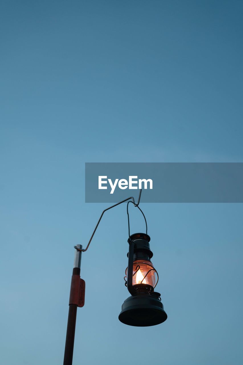 Low angle view of street light against blue sky