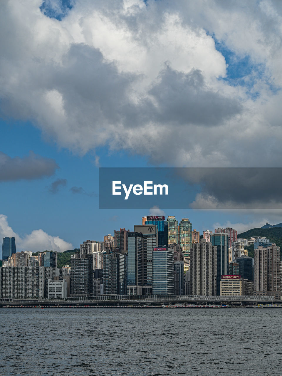 Buildings in city against cloudy sky