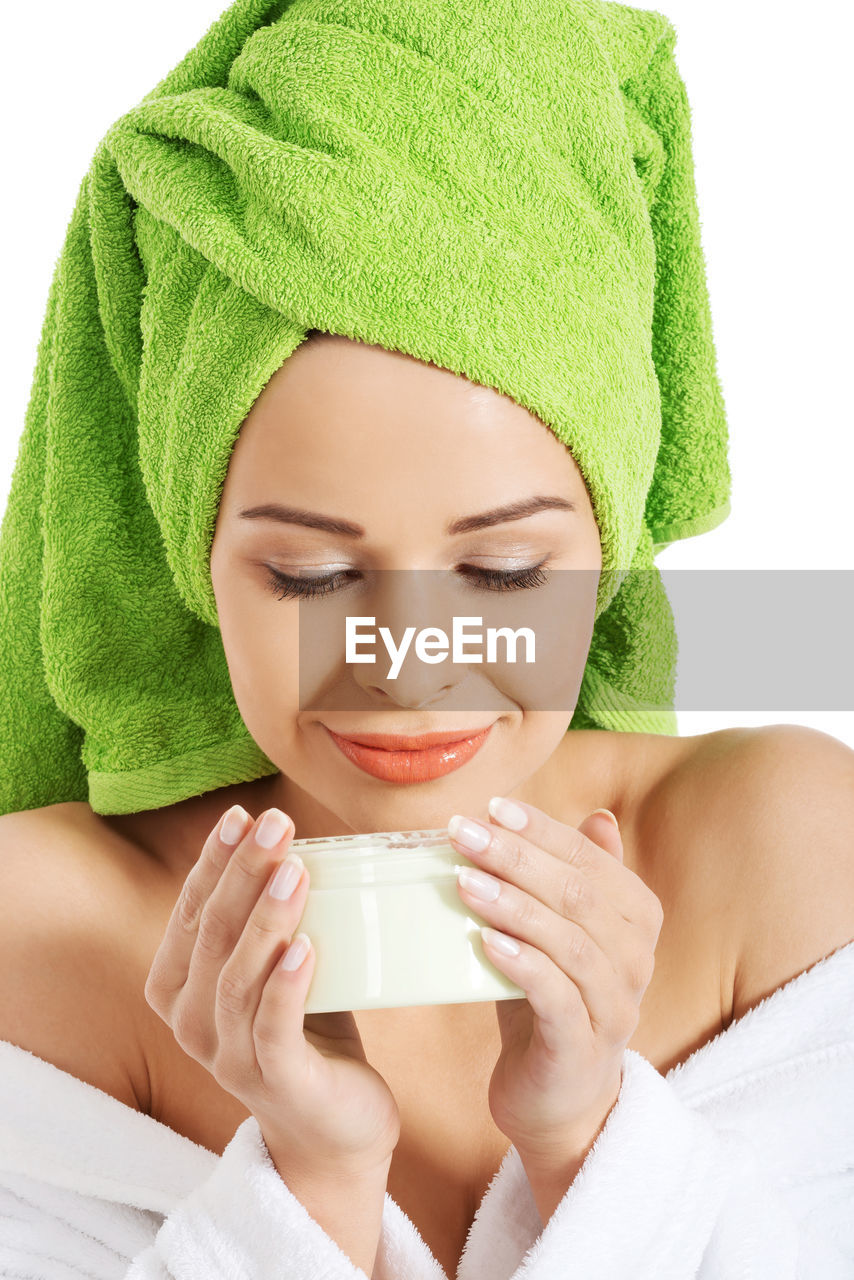 Woman holding cream box against white background