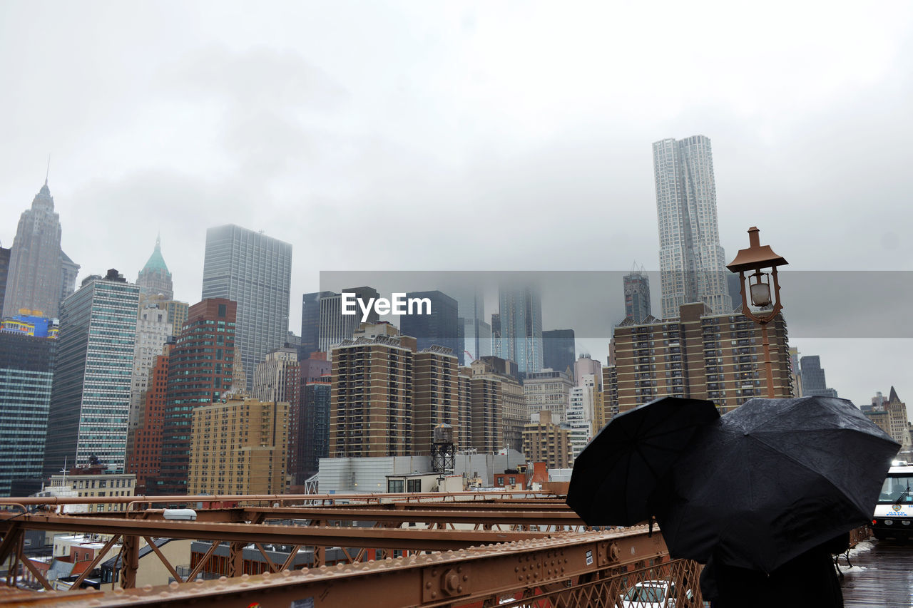 Rear view of modern cityscape against sky