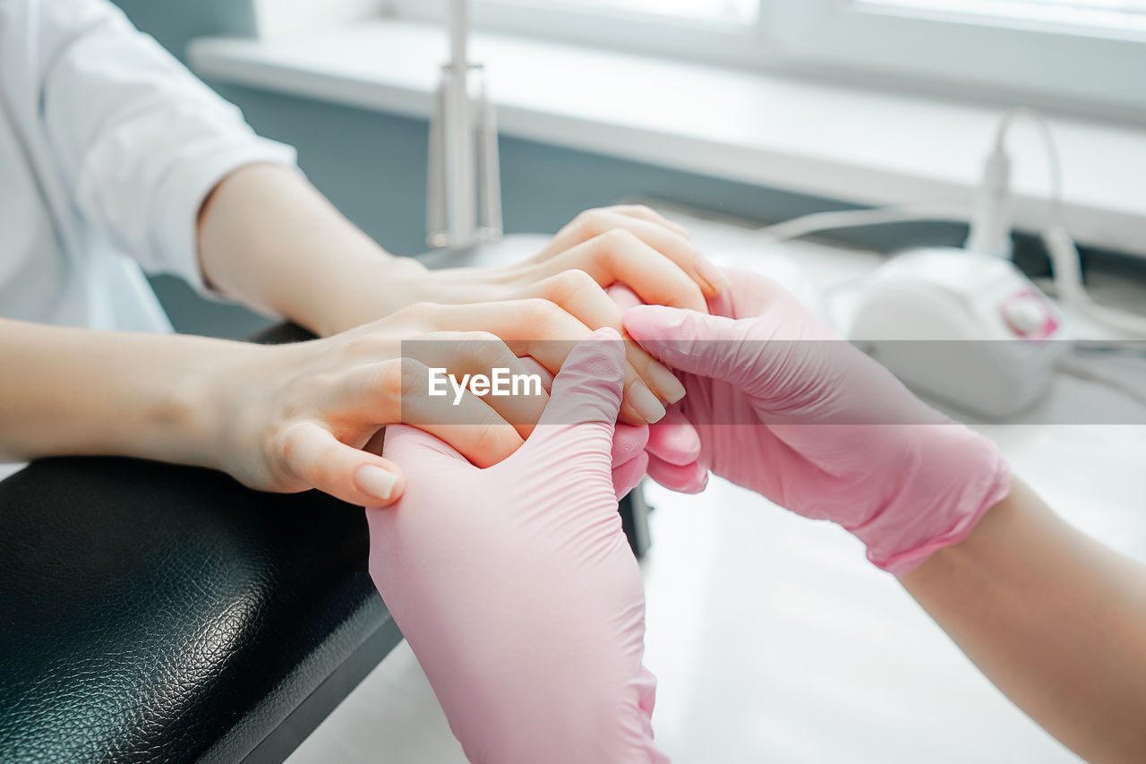 MIDSECTION OF WOMAN HOLDING HANDS OF PERSON