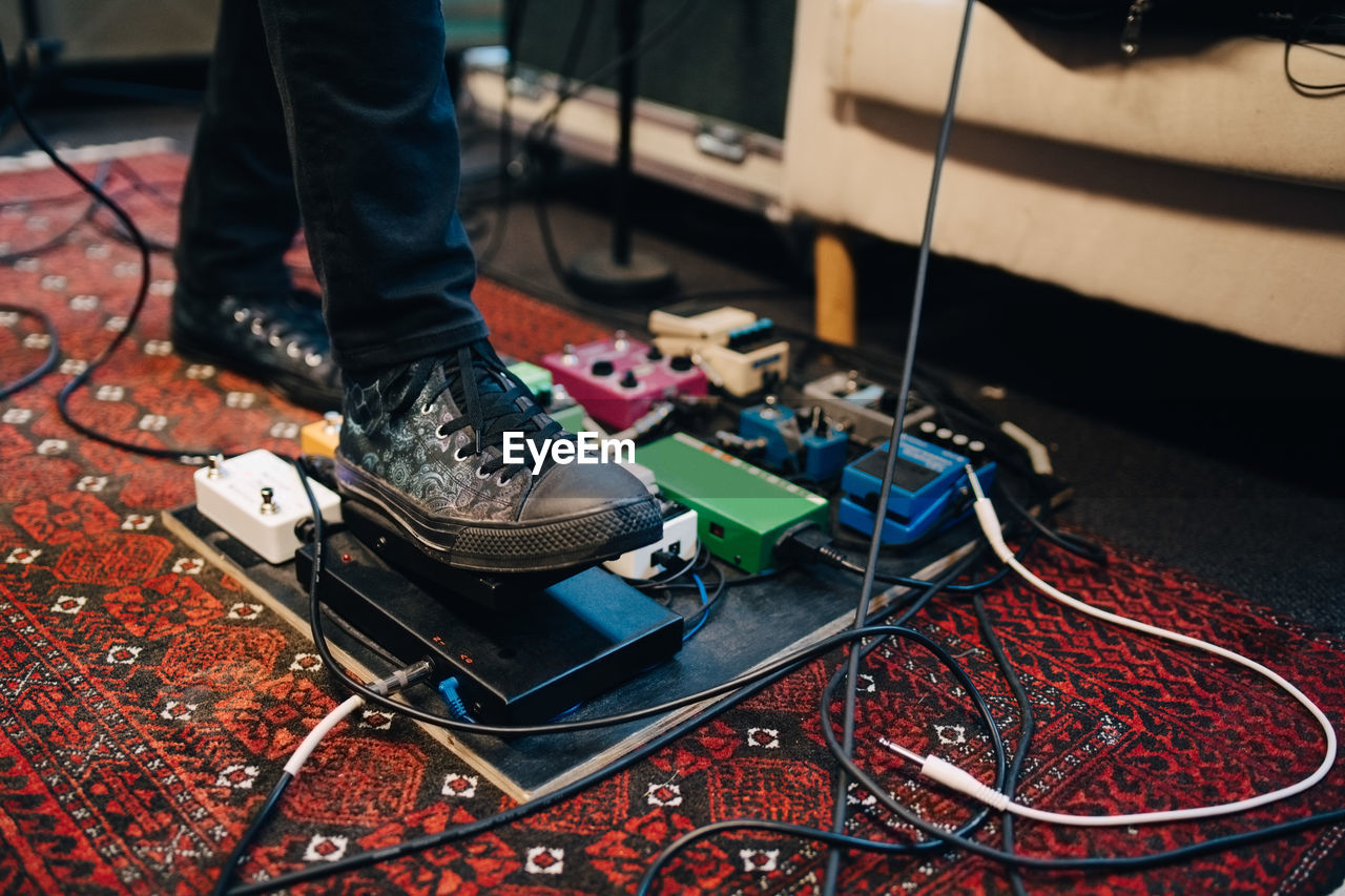 Low section of man using equipment while practicing in recording studio