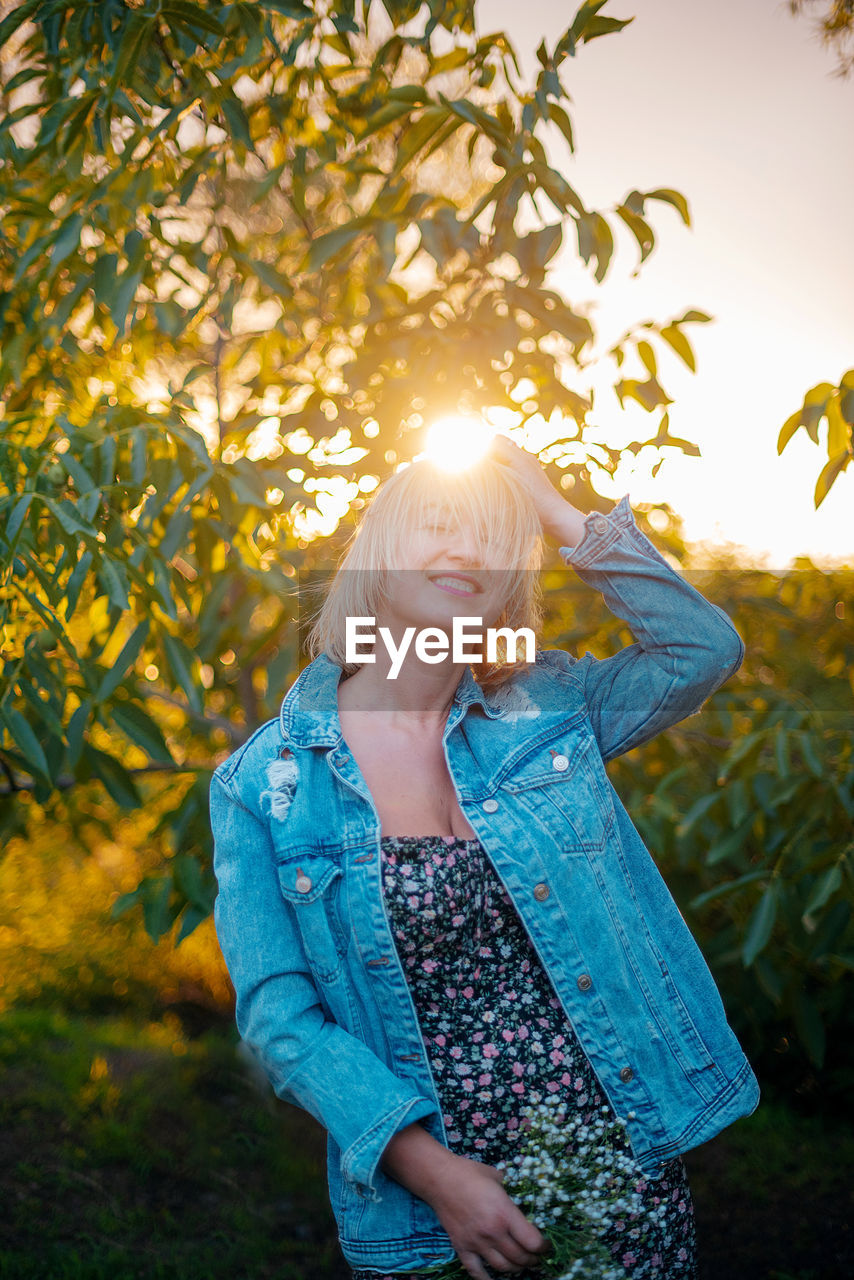 Young woman standing against plants