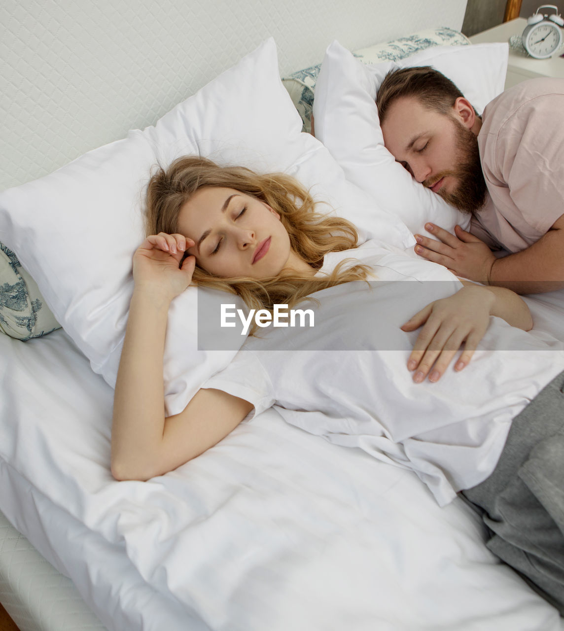 High angle view of man and woman sleeping on bed at home