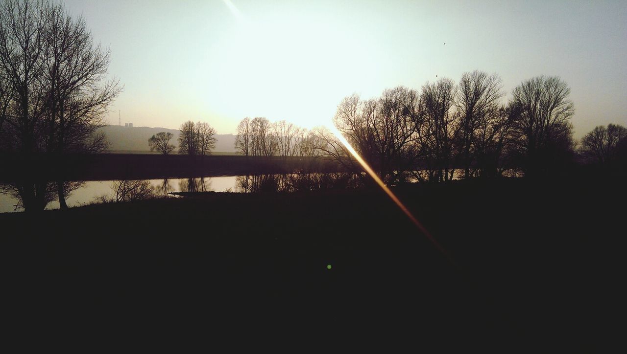 Scenic view of silhouette field against clear sky at sunset