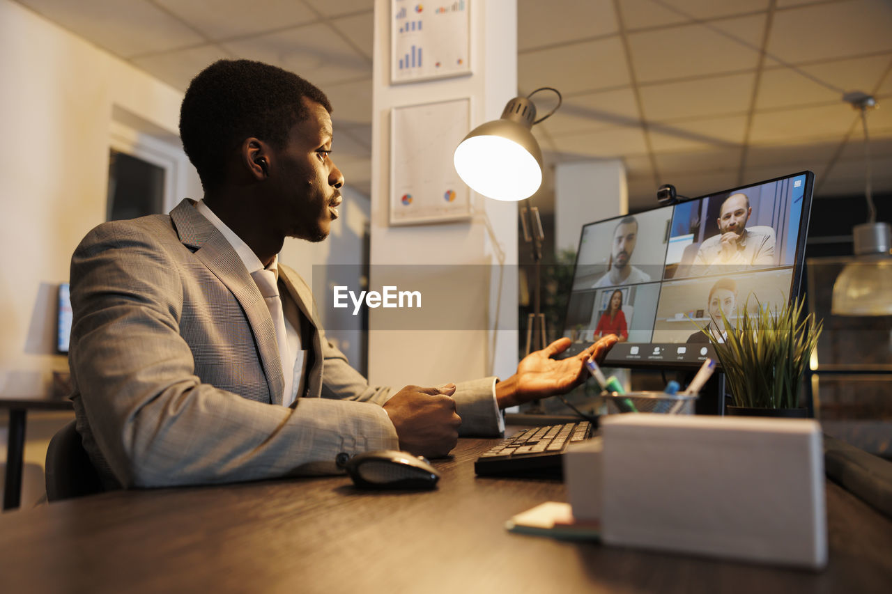 side view of man using laptop while sitting in office