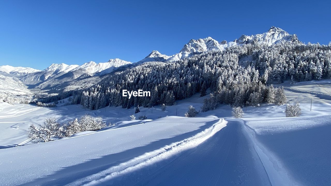 SNOWCAPPED MOUNTAINS AGAINST BLUE SKY