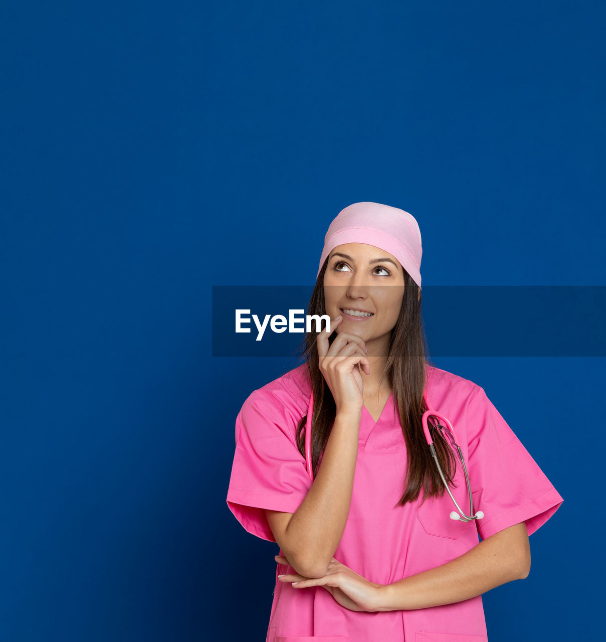 WOMAN STANDING AGAINST PINK BACKGROUND