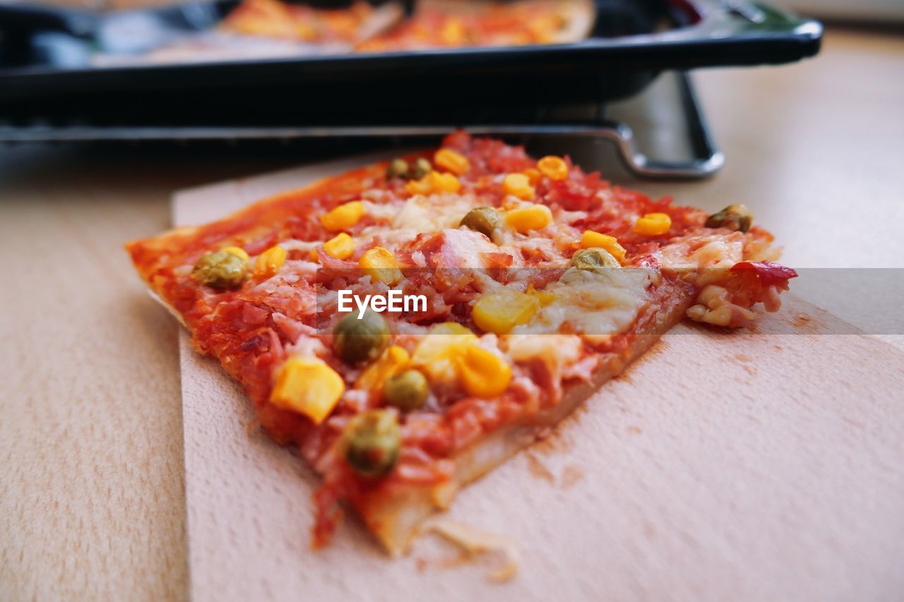 HIGH ANGLE VIEW OF PIZZA SERVED ON TABLE