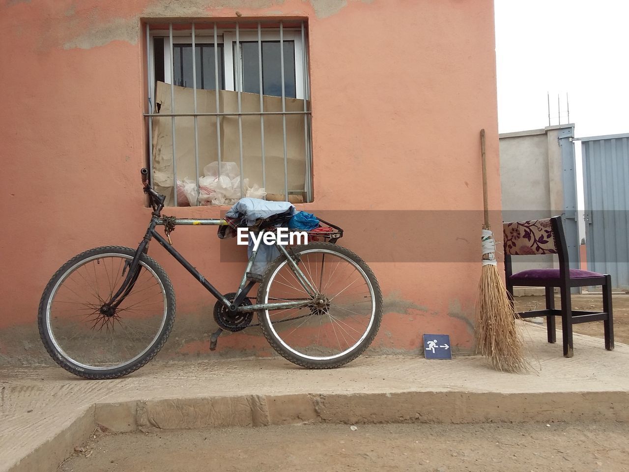 BICYCLE PARKED AGAINST BUILDING