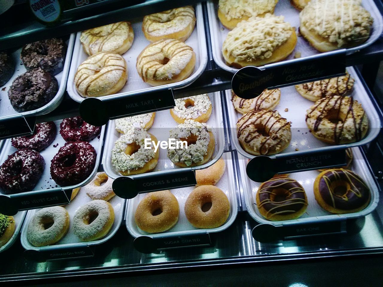 High angle view of donuts in display cabinets at store for sale