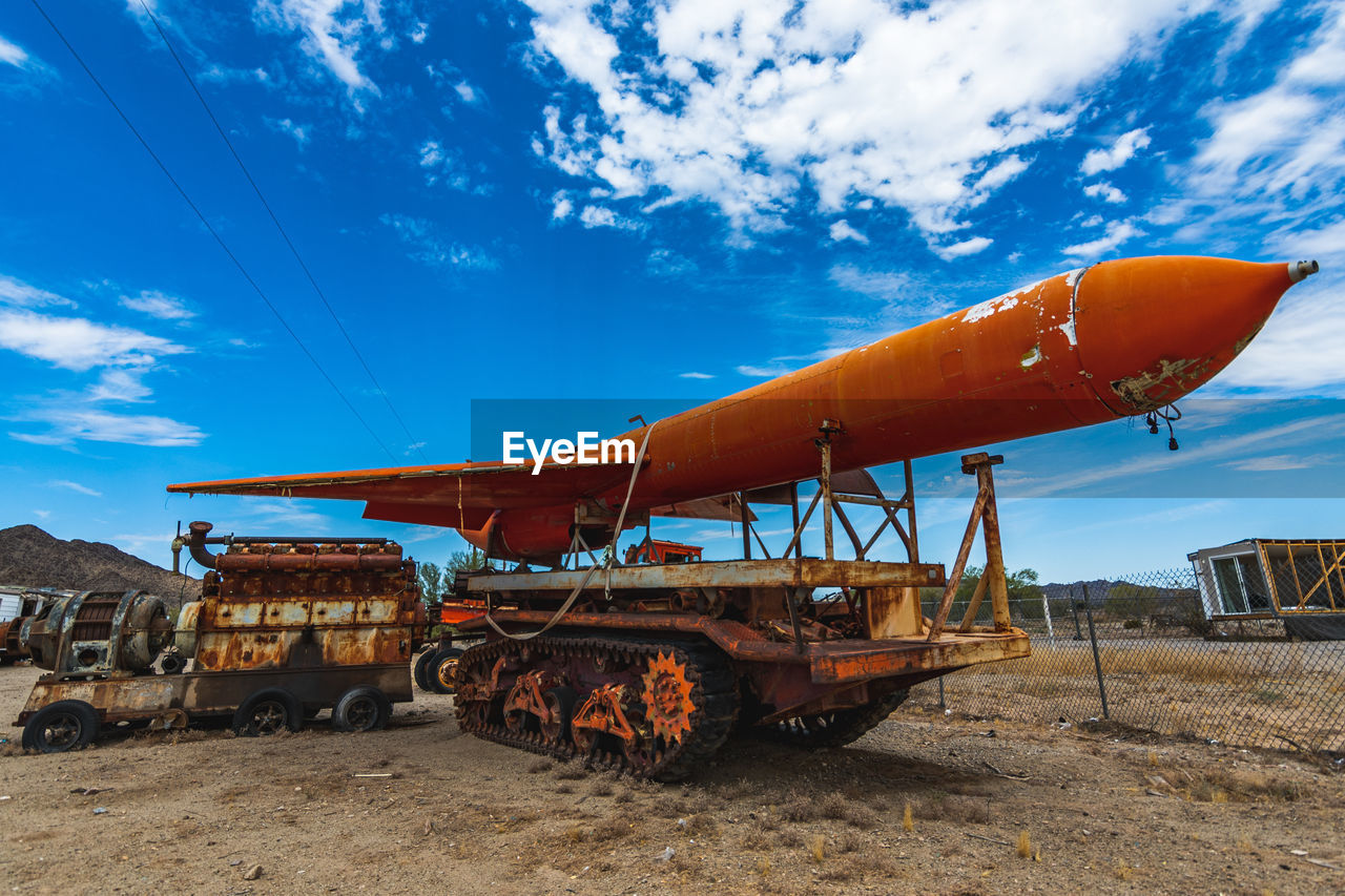 Rusty metallic structure on field against sky