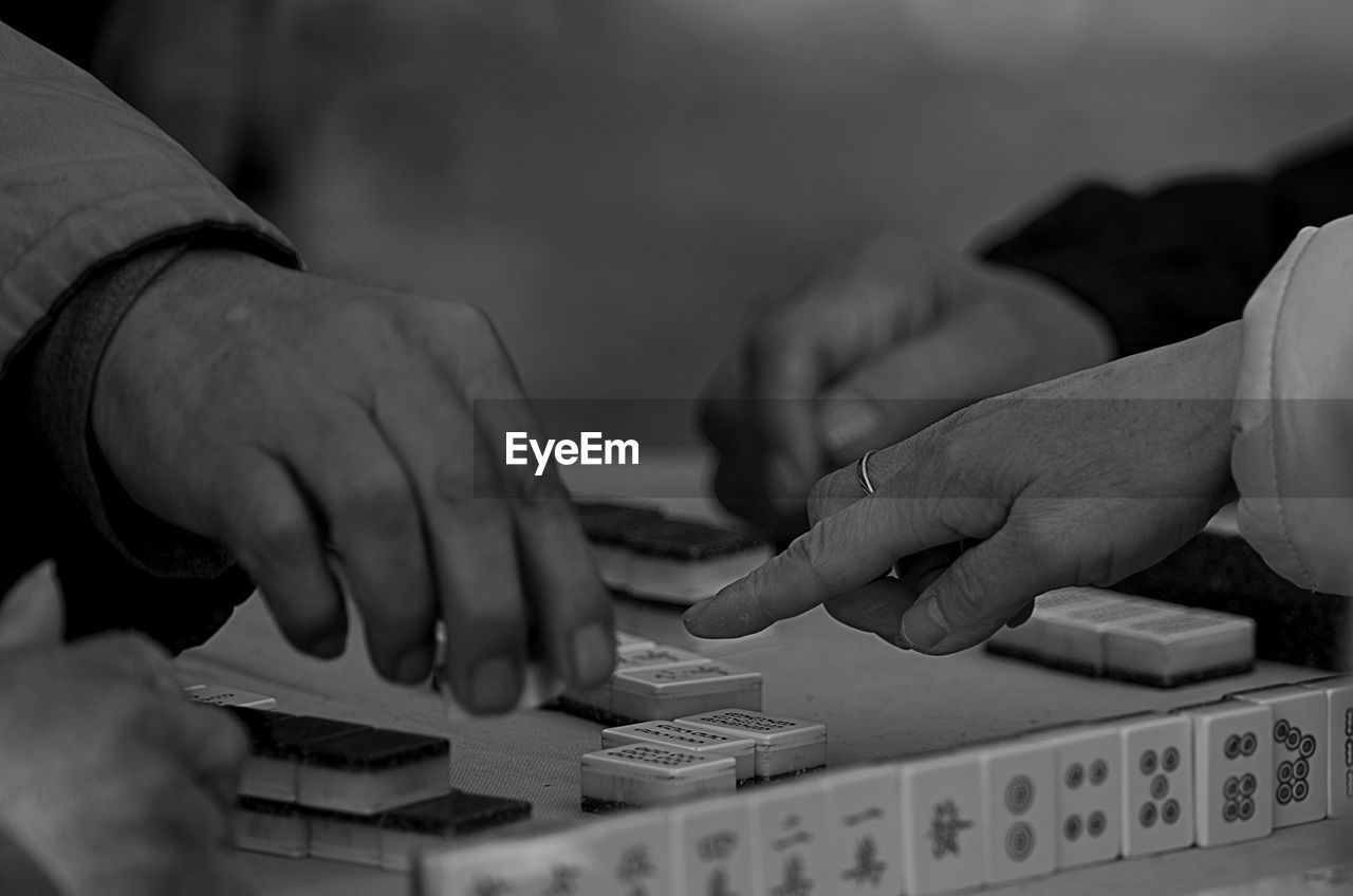 Cropped hands playing with gambling chips on table